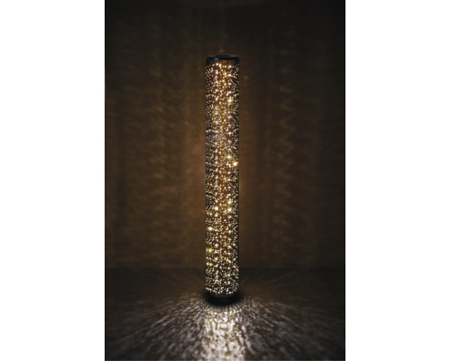 Lampă solară de podea cilindrică, din metal cu perforații fine, care emite o lumină caldă, sclipitoare, cu efect de stele.