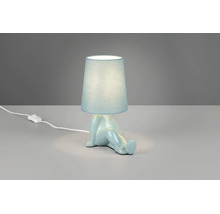 Veioză albastru deschis cu bază din ceramică în formă de figură așezată și abajur din material textil cu întrerupător pe fir.