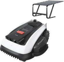 Robot de tuns gazonul cu garaj în negru și alb, cu buton de oprire roșu și anvelope de teren.