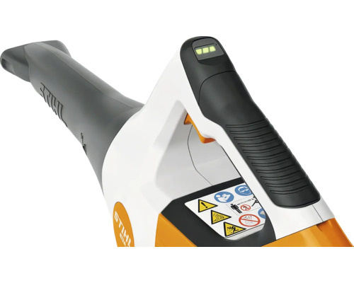 Vedere detaliată a unei suflante de frunze cu acumulator, cu mâner ergonomic, indicator de încărcare, instrucțiuni de siguranță și STIHL Logo.