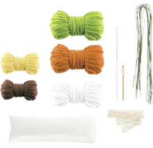 Set de creație cu diverse gheme de lână, dantelă, ace, fir verde și o bucată de material textil alb pentru lucru manual.