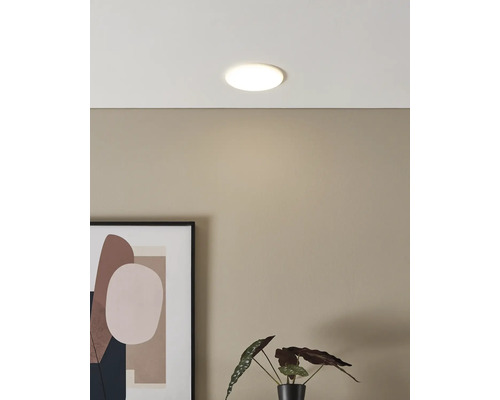 Plafonieră LED rotundă și plată într-o cameră cu design modern, cu un tablou și o plantă de apartament.