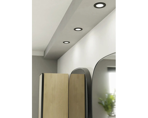 Spoturi LED încorporate negre într-un plafon luminos deasupra unui dulap de baie și a oglinzilor.