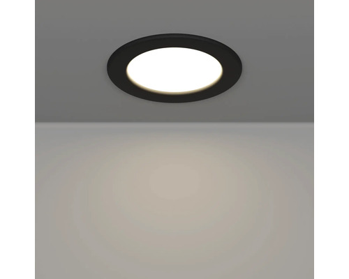 Spot LED încorporabil rotund, negru, montat pe tavan și aprins.