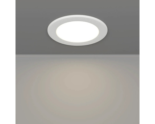 Spot LED încorporabil rotund, alb, aprins cu fascicul de lumină pe perete.