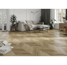 Cameră de zi luminoasă cu parchet din stejar cu model chevron, canapea modernă și plante de apartament.