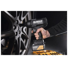 Mașină de înșurubat cu impact cu acumulator DeWALT 18 Volt McLaren Limited Edition utilizată pe o jantă auto.