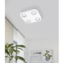 Plafonieră LED modernă pătrată cu patru surse de lumină rotunde într-o cameră luminoasă cu raft și plante de apartament.
