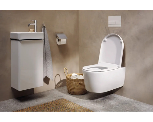 Toaletă modernă pentru oaspeți cu WC suspendat, mască pentru chiuvetă albă, lavoar și coș de răchită pe perete cu aspect de beton.