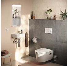 Toaletă modernă pentru oaspeți cu WC suspendat, lavoar mic, oglindă cu iluminare și faianță cu aspect de beton.