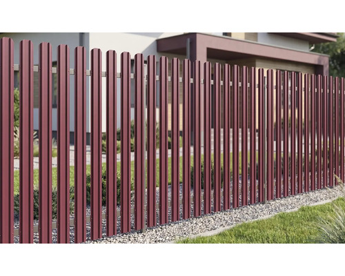 Gard metalic modern din profiluri verticale într-o grădină luminoasă și organizată în fața unei case.