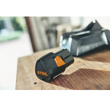 Acumulator litiu-ion Stihl AS 2 pentru sistemul AS pe o suprafață de lemn.