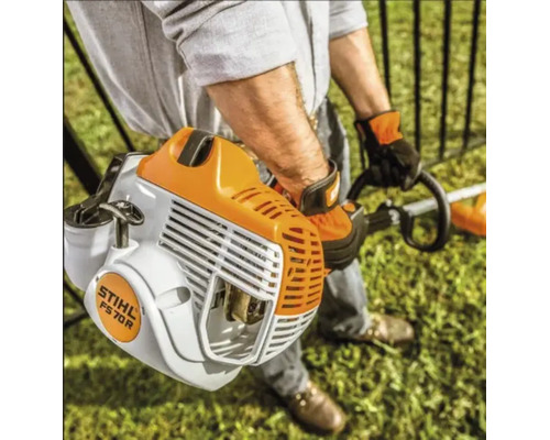 Persoană care utilizează o motocoasă pe benzină STIHL FS 70 R pentru îngrijirea gazonului într-o grădină luminoasă.