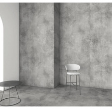 Amenajare modernă cu panouri de perete și pardoseală cu aspect de beton, scaun de bar și măsuță minimalistă.