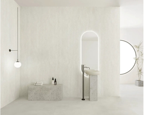 Baie modernă, luminoasă, cu aspect de piatră, cu chiuvetă tip coloană, oglindă ovală cu LED, baterie stativă și corp de iluminat minimalist.