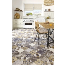 Bucătărie luminoasă cu gresie cu model patchwork, aragaz alb, masă de dining din lemn și scaune din răchită.