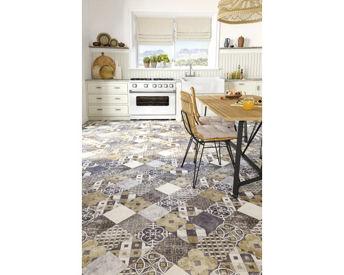 Bucătărie luminoasă cu gresie cu model patchwork, aragaz alb, masă de dining din lemn și scaune din răchită.