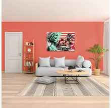 Sufragerie mobilată modern, cu canapea, măsuță rotundă, plantă de apartament și un tablou pop art cu motive din Statele Unite ale Americii.