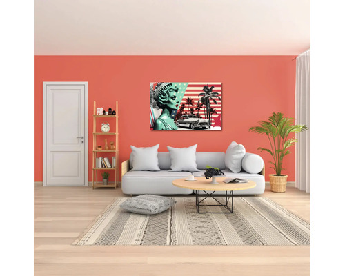 Sufragerie mobilată modern, cu canapea, măsuță rotundă, plantă de apartament și un tablou pop art cu motive din Statele Unite ale Americii.