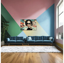 Sufragerie modernă luminoasă cu perete geometric colorat, două canapele din catifea albastră, covor alb pufos și tablou modern pe pânză.