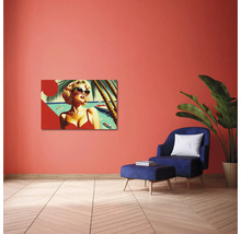 Sufragerie modernă cu tablou pop-art pe perete teracota, fotoliu albastru cu otoman și plantă de interior mare.