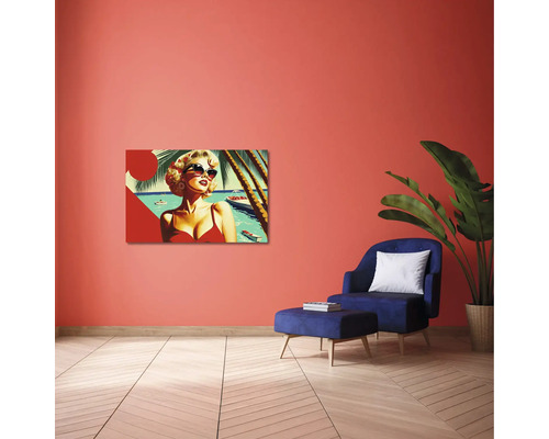 Sufragerie modernă cu tablou pop-art pe perete teracota, fotoliu albastru cu otoman și plantă de interior mare.