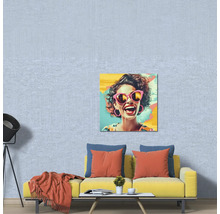 Living modern cu o canapea galbenă, perne, o măsuță de cafea și un tablou pop art pe un tapet texturat albastru deschis.