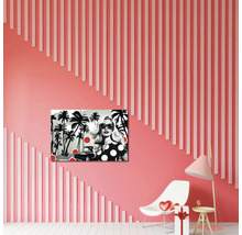 Tablou pop art cu o femeie și palmieri într-o cameră modernă cu perete somon decorat cu șipci verticale, scaun de design și lampă.