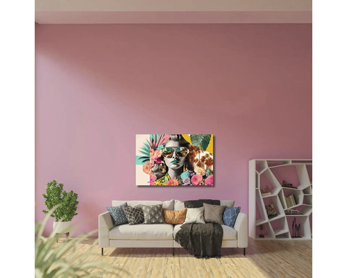 Living modern cu tablou reprezentând o femeie cu ochelari de soare deasupra unei canapele, plantă de interior și raft geometric.