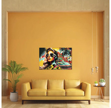 Living modern cu un tablou pe pânză pop art colorat cu o femeie, o mașină și palmieri deasupra unei canapele galbene.