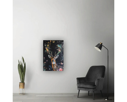 Tablou cu motiv cerb și flori într-o cameră de zi modernă, cu fotoliu gri și plantă de interior.