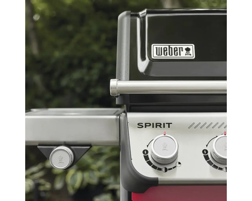 Vedere de aproape a unui grătar cu gaz Weber Spirit cu butoane de control, Weber Logo și mâner din oțel inoxidabil.