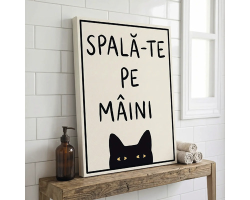 Tablou canvas cu textul SPALĂ-TE PE MÂINI și ilustrație cu o pisică neagră, pe o poliță de lemn în baie lângă un dozator de săpun și prosoape.