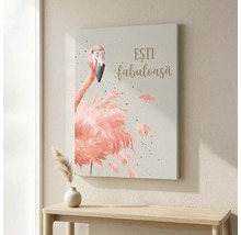 Tablou pe pânză cu ilustrația unui flamingo roz și textul ESTI fabuloasa deasupra unei mese de lemn într-o cameră luminoasă.