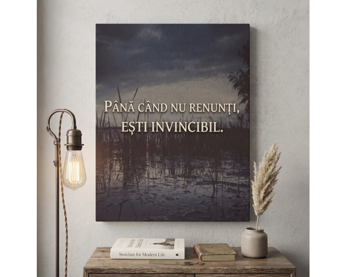 Tablou pe pânză cu citatul Până când nu renunți, ești invincibil pe fundalul unui lac la amurg, decor interior cu lampă și cărți.