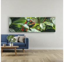 Tablou panoramic pe pânză cu motiv cameleon deasupra unei canapele albastre într-o cameră de zi luminoasă.