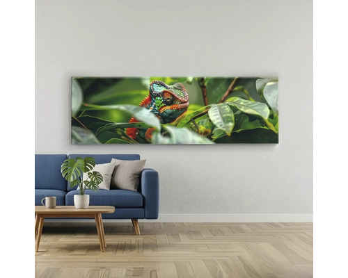 Tablou panoramic pe pânză cu motiv cameleon deasupra unei canapele albastre într-o cameră de zi luminoasă.