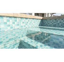 Piscină cu mozaic pe pereți și trepte, apă limpede și borduri din piatră.