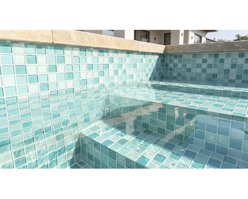 Piscină cu mozaic pe pereți și trepte, apă limpede și borduri din piatră.