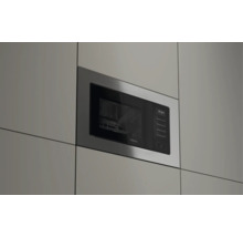 Cuptor cu microunde încorporabil Teka cu ramă din inox, panou frontal din sticlă neagră, afișaj digital și comenzi tactile.