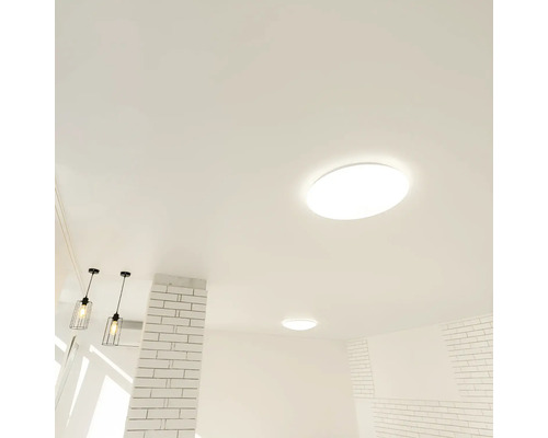 Design modern și luminos al încăperii, cu plafoniere rotunde și pendule tip colivie din sârmă neagră pe un tavan alb.