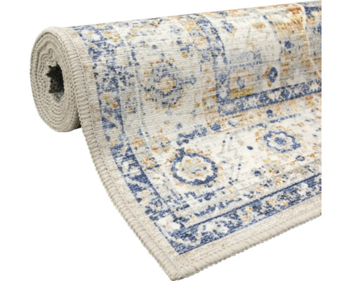 Traversă de covor parțial rulată cu model oriental vintage în albastru și bej, țesătură plată cu margini surfilate.