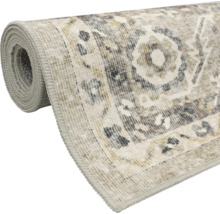 Covor în stil vintage, parțial rulat, cu model ornamental oriental și margine surfilată.