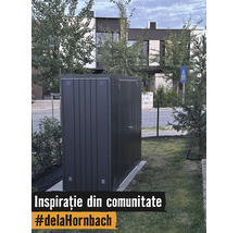 Căsuță de grădină modernă din metal gri închis amplasată pe gazon în curtea unei case.