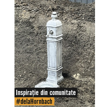 Cișmea decorativă de grădină cu aspect de piatră, robinet metalic și bazin pe pământ.