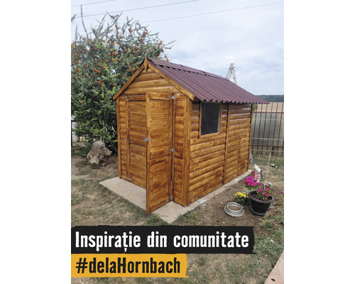 Căsuță de grădină din lemn cu acoperiș în două ape și ușă deschisă pe o fundație de beton în grădină.