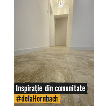 Coridor luminos cu gresie de format mare cu aspect de piatră naturală, pereți albi și plafonieră modernă.
