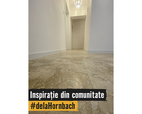 Coridor luminos cu gresie de format mare cu aspect de piatră naturală, pereți albi și plafonieră modernă.