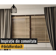 Fereastră modernă cu rulouri din bambus, draperii gri groase, o lustră neagră tip plasă și un calorifer.