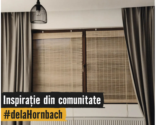 Fereastră modernă cu rulouri din bambus, draperii gri groase, o lustră neagră tip plasă și un calorifer.